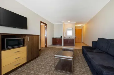 a living room with a couch and a flat screen tv at Best Western Los Angeles Worldport Hotel in Wilmington