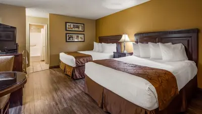a hotel room with two beds and a television at Empire Inn in San Bernardino