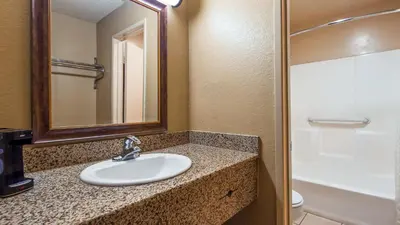 a bathroom with a sink and a mirror and a toilet at Empire Inn in San Bernardino
