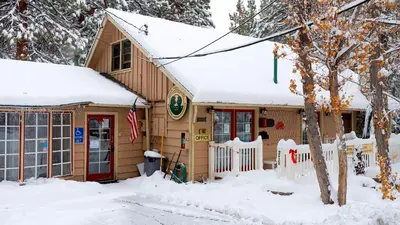 a small house with snow on the roof at Sleepy Forest Cottages in Big Bear Lake