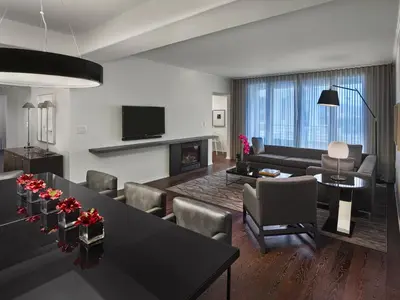 a living room with a table and a couch and a fireplace at AKA Beverly Hills in Los Angeles