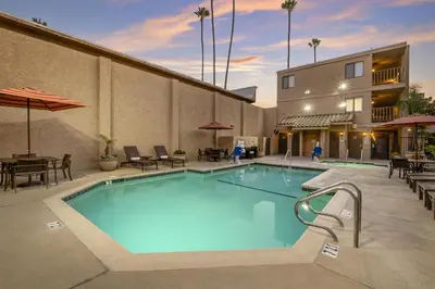 a pool at a hotel with tables and chairs at Best Western Plus Anaheim Inn in Anaheim