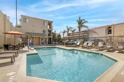 a swimming pool with chairs and a building at Best Western Plus Anaheim Inn in Anaheim