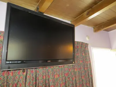 a large flat screen tv hanging on a wall at Park Cienega Motel in Los Angeles