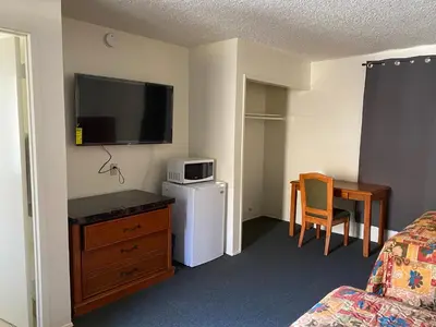 a hotel room with a television on the wall at Golden Hills Motel in Tehachapi