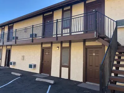 an apartment building with a balcony and two doors at Golden Hills Motel in Tehachapi