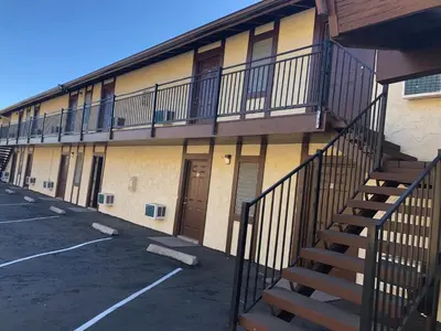 a building with a staircase next to a parking lot at Golden Hills Motel in Tehachapi