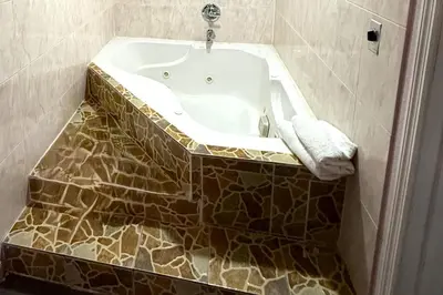 a bath tub in a bathroom with a tiled floor at Travel Inn Downtown LA in Los Angeles