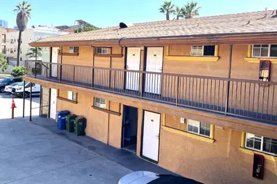 an apartment building with a balcony and a parking lot at Travel Inn Downtown LA in Los Angeles