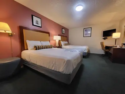 a hotel room with two beds and a desk at Star Inn On Route 66, Barstow in Barstow