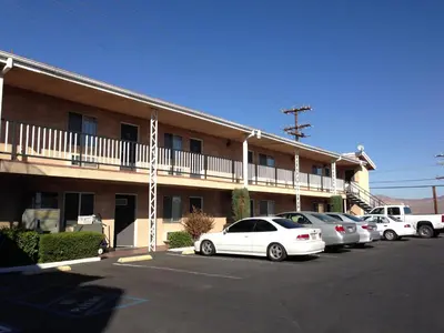 a building with cars parked in a parking lot at Star Inn On Route 66, Barstow in Barstow
