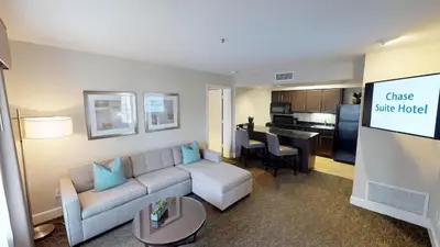 a living room with a couch and a table at Chase Suites Brea-Fullerton - North Orange County in Brea