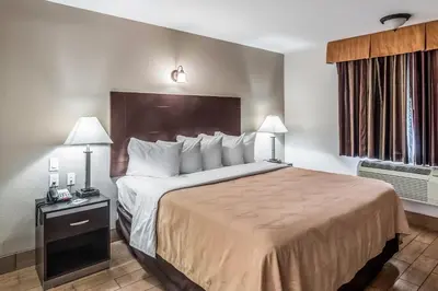 a hotel room with a large bed and two lamps at Quality Inn & Suites near Downtown Bakersfield in Bakersfield