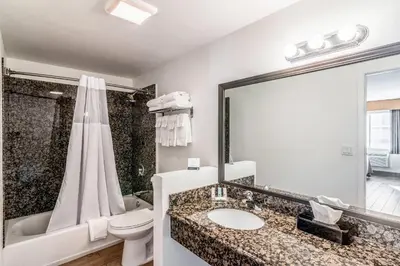 a bathroom with a sink and a toilet and a tub at Quality Inn & Suites near Downtown Bakersfield in Bakersfield