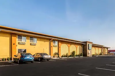 two cars parked in a parking lot in front of a building at Quality Inn & Suites near Downtown Bakersfield in Bakersfield