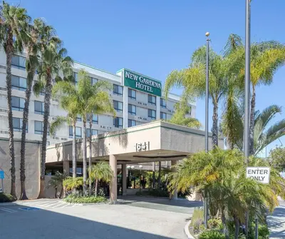a hotel with palm trees in front of a building at New Gardena Hotel in Gardena