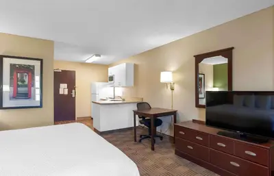 a hotel room with a bed and a desk and a kitchen at Extended Stay America Suites - Los Angeles - Chino Valley in Chino