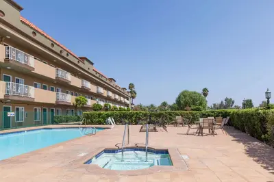a pool with tables and chairs next to a building at Travelodge by Wyndham Sylmar CA in Sylmar