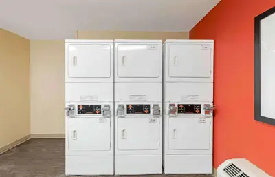 four white refrigerators are lined up against a wall at Extended Stay America Suites - Los Angeles - Valencia in Stevenson Ranch