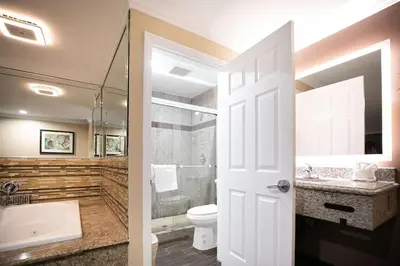 a bathroom with a toilet and a shower and a sink at Rodeway Inn & Suites Bellflower in Bellflower