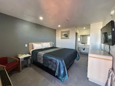 a hotel room with a bed and a television at California Inn Hotel and Suites Adelanto US 395 in Adelanto