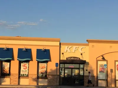 a man walking past two stores with blue awnings at California Inn Hotel and Suites Adelanto US 395 in Adelanto
