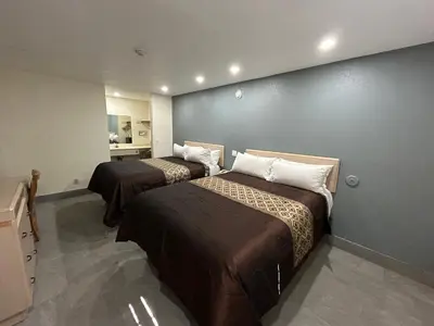 two beds in a room with a wall at California Inn Hotel and Suites Adelanto US 395 in Adelanto