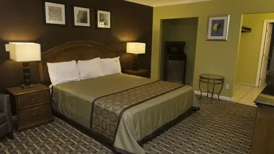 a hotel room with a bed and two lamps at Kings Motel Inglewood in Inglewood