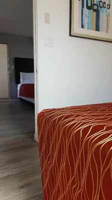 a bedroom with a bed with a red and orange blanket at Guest Harbor Inn- Port Of Los Angeles San Pedro in San Pedro