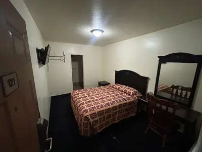 a bedroom with a bed and a large mirror at Budget Inn Motel in South Gate