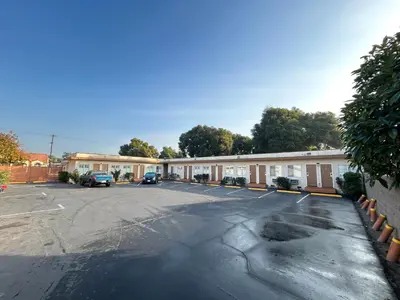 an empty parking lot in front of a building at Budget Inn Motel in South Gate