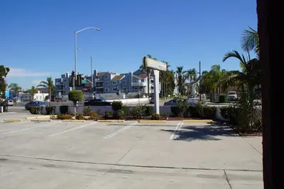 a parking lot with a sign in front of a building at Beach Inn in Long Beach