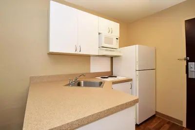 a small kitchen with a sink and a white refrigerator at Extended Studio Hotel Suites - Los Angeles - San Dimas in San Dimas
