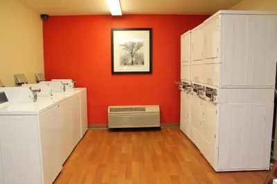 a room with white cabinets and an orange wall at Extended Studio Hotel Suites - Los Angeles - San Dimas in San Dimas