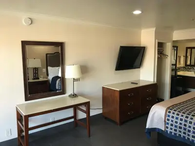 a hotel room with a bed and a mirror at Economy Inn LAX Inglewood in Inglewood