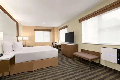 a hotel room with a bed and a flat screen tv at Wyndham Anaheim in Anaheim