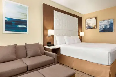 a hotel room with a bed and a couch at Wyndham Anaheim in Anaheim