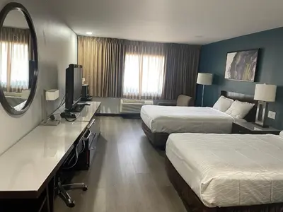 a hotel room with two beds and a mirror at Portside Inn & suites in San Pedro