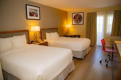 a hotel room with two beds and a window at Ramada Plaza by Wyndham Garden Grove/Anaheim South in Anaheim