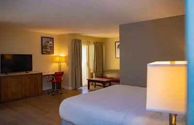 a hotel room with a bed and a television at Ramada Plaza by Wyndham Garden Grove/Anaheim South in Anaheim