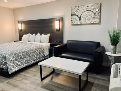 a hotel room with a bed and a chair at Sakura Inn in Glendale