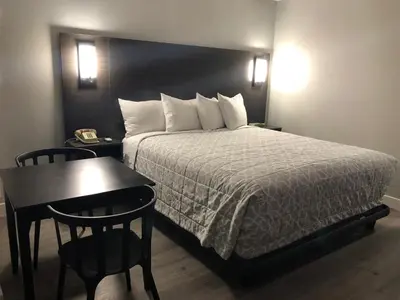 a hotel room with a bed and a table and a phone at Sakura Inn in Glendale