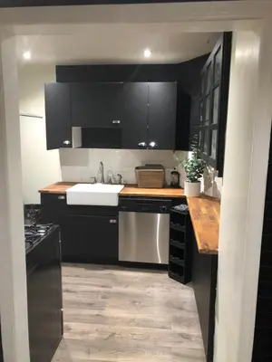 a kitchen with black cabinets and a white sink at VacaStay on Scandia Way in Los Angeles