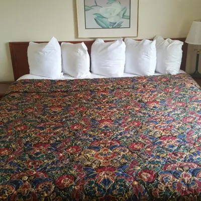 a bed in a hotel room with a colorful bedspread at Days Inn by Wyndham Orange Anaheim in Orange