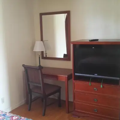 a bedroom with a desk with a television and a mirror at Days Inn by Wyndham Orange Anaheim in Orange