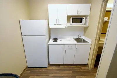 a small kitchen with a white refrigerator and a sink at Extended Stay America Suites - Bakersfield - California Avenue in Bakersfield