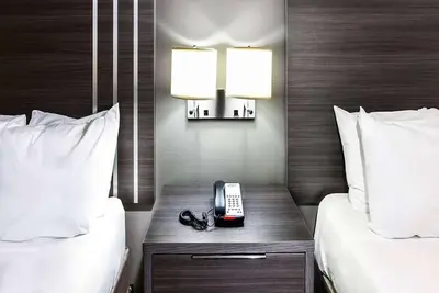 a hotel room with two beds and a phone on a table at Travelodge by Wyndham Commerce Los Angeles Area in Commerce