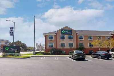 a hotel with two cars parked in a parking lot at Extended Stay America Suites - Los Angeles - Torrance Blvd in Torrance