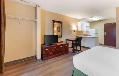 a hotel room with a bed and a desk with a television at Extended Stay America Suites - Los Angeles - Ontario Airport in Guasti