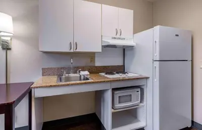 a kitchen with white cabinets and a sink and a refrigerator at Extended Stay America Suites - Los Angeles - Ontario Airport in Guasti